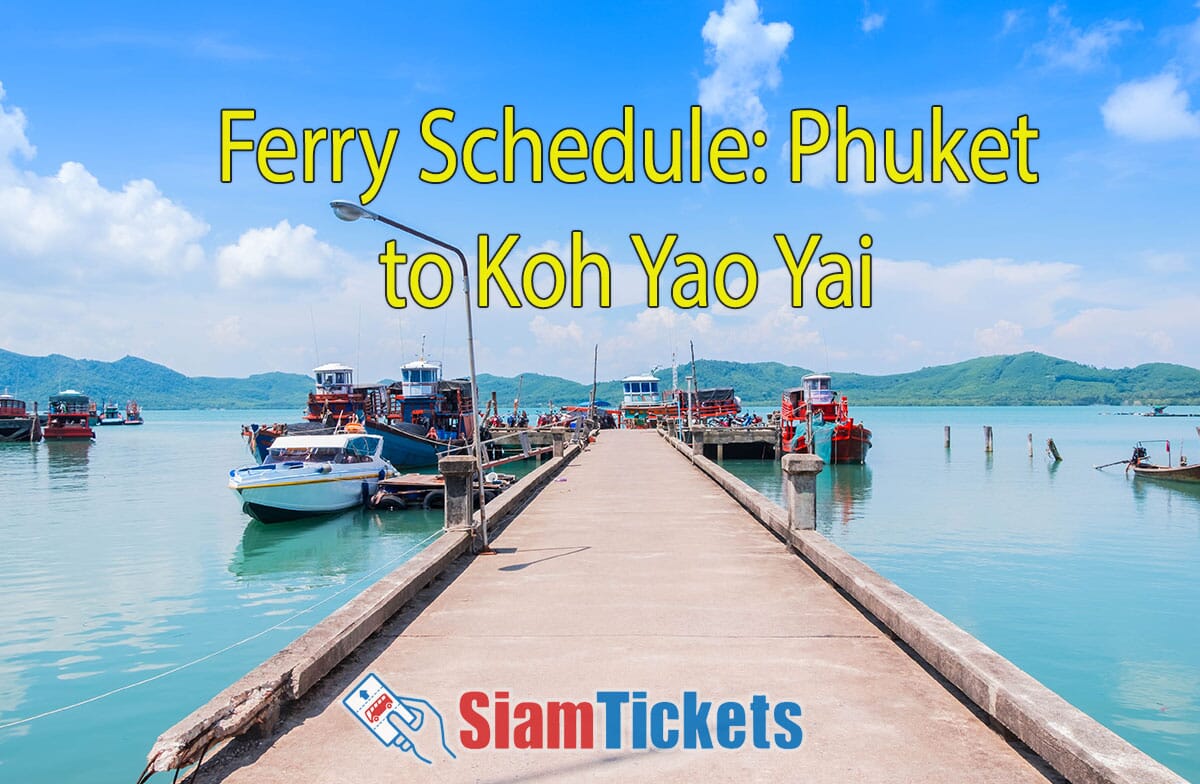 Scenic view of the bay at Koh Yao Yai, Phang Nga, Thailand. A pier extends into the water with several boats docked on either side. The background features green hills under a bright blue sky. Text "Ferry Schedule: Phuket to Koh Yao Yai" is displayed at the top in yellow.