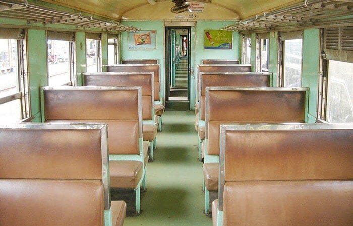 Interior view of a 3rd Class fan seat carriage showing wooden seats and open windows